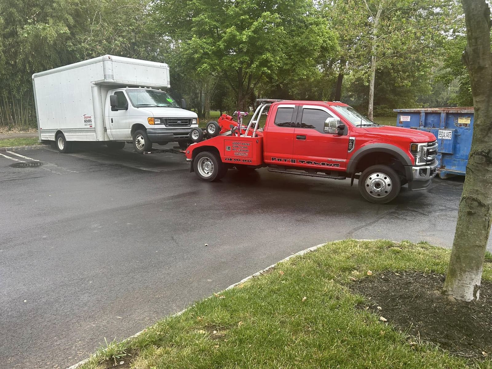 Red Pat's Towing truck towing a large box moving truck